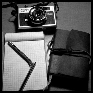 immagine di un block notes di un taccuino e di una macchina fotografica