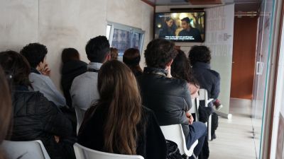 Giovani che guardano una tv all'interno del bus