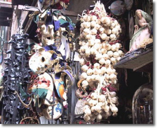 maschere, treccia d'aglio ed elementi di presepe, esposti all'esterno di una bottega