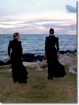 Un'immagine del film "lezioni di piano". Due donne vestite di nero guardano verso il mare.