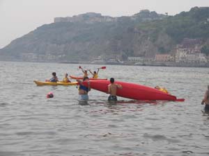 due ragazzi capovolgono una canoa in acqua