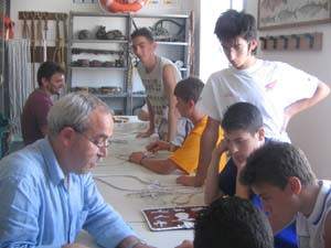 ragazzi guardano un docente intorno ad un lungo tavolo