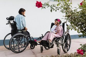 immagine di due bambine in sedia a rotelle che si parlano